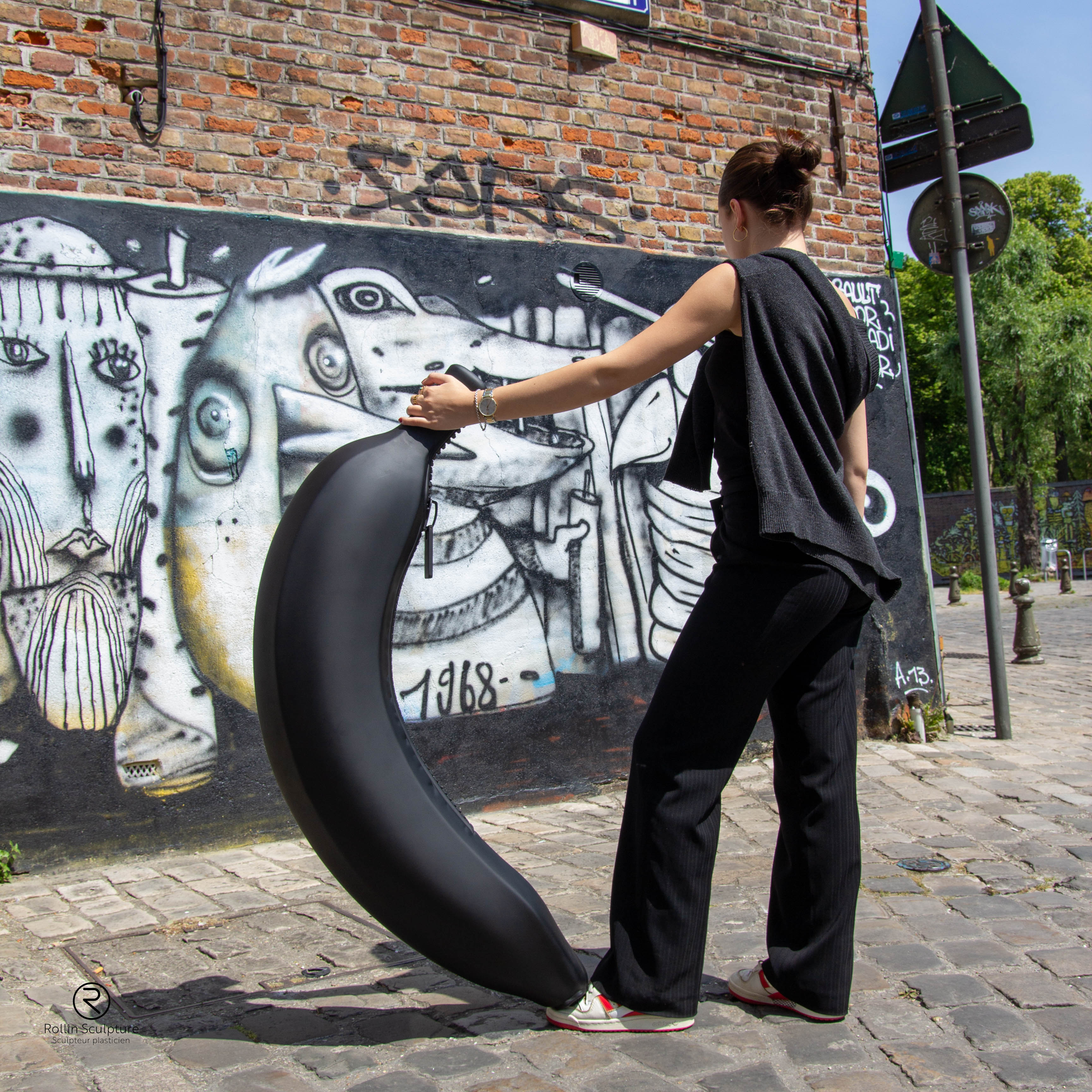 jeune femme qui tient une sculpture de banane